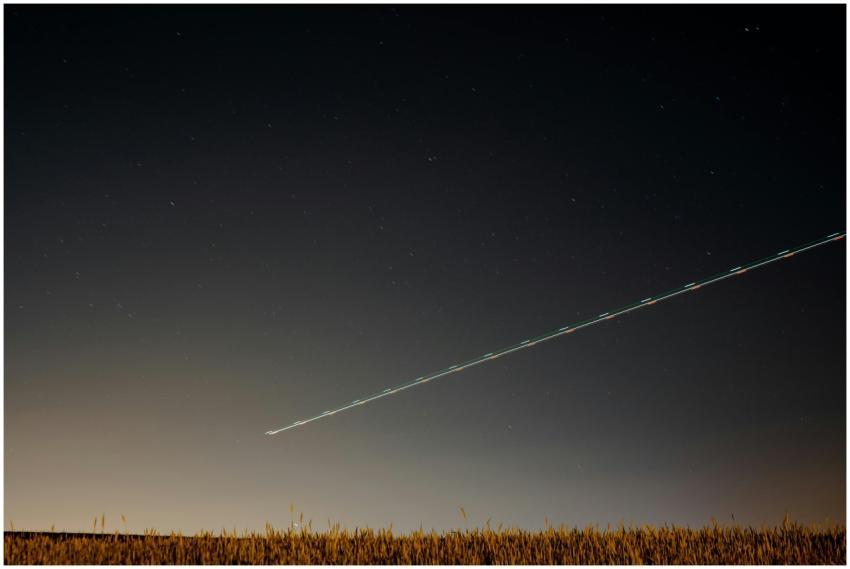 A serene night sky over the countryside with a lig