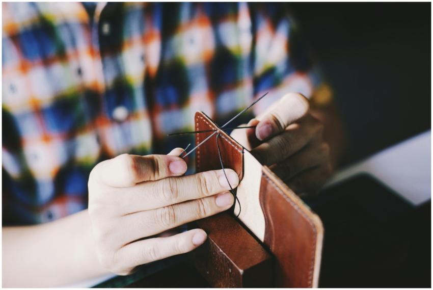 Close-up of a person hand-stitching leather, showc
