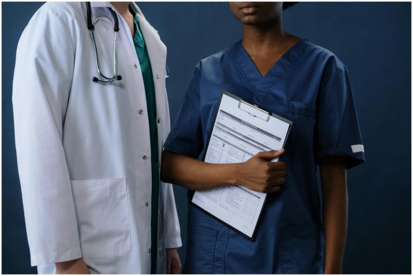 Two healthcare professionals in scrubs and lab coa
