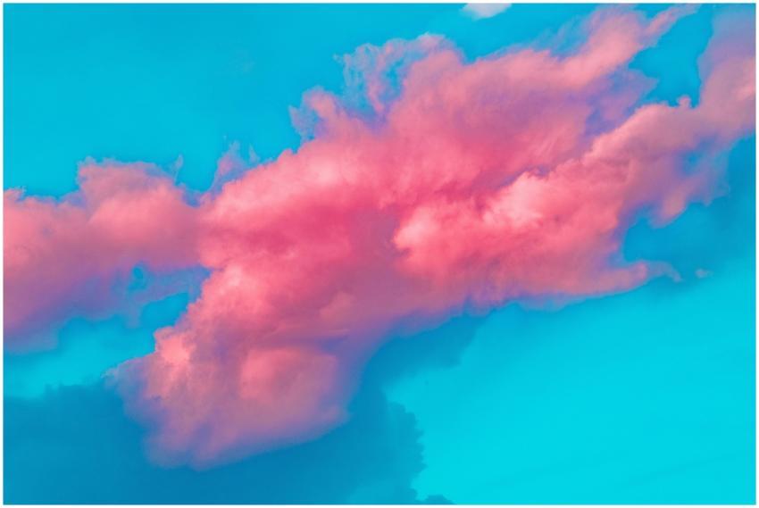 A vibrant pink cloud against a bright blue sky, sh