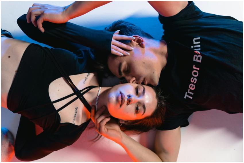 A young couple embracing in a relaxed pose under v