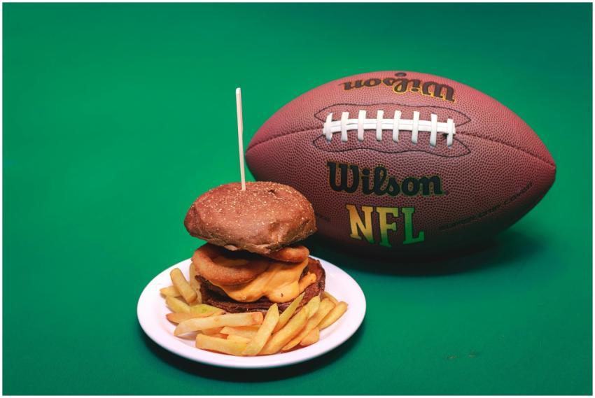 A cheeseburger and fries on a plate with a Wilson