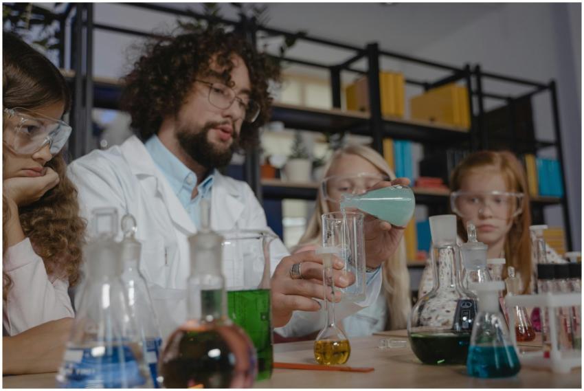 Diverse students in protective goggles study chemi