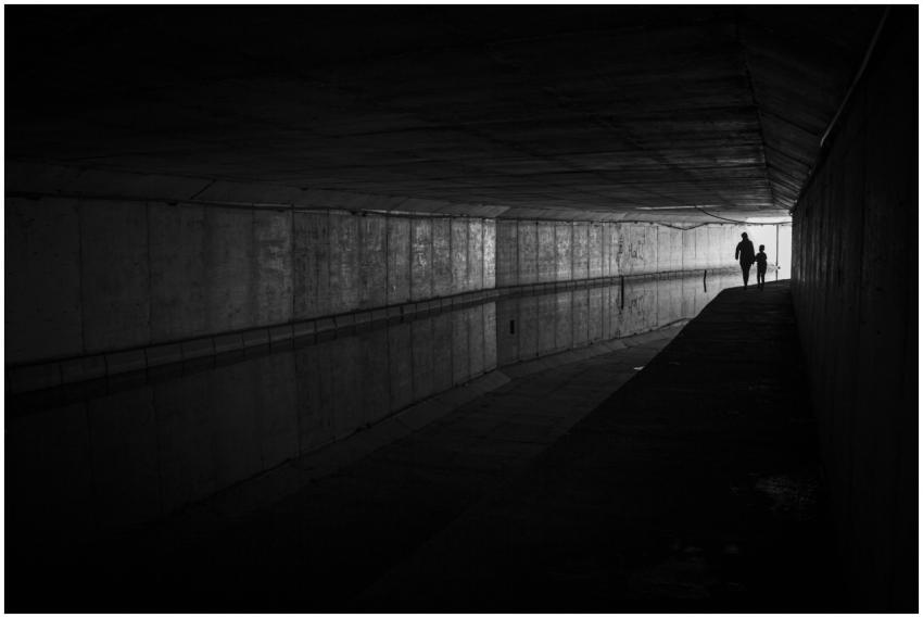 Moody black and white photo of silhouettes walking