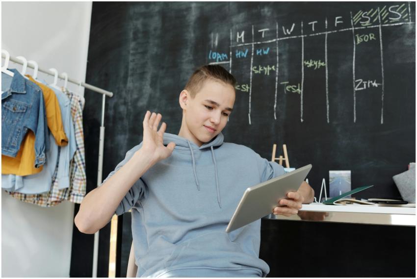 A teenager uses a tablet for online learning in a