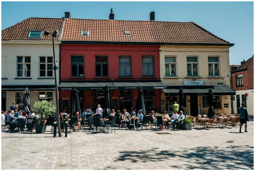 Sunlit outdoor cafe in Bruges, Belgium with touris