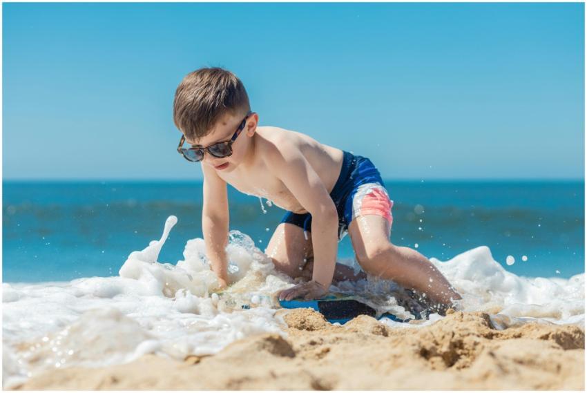 Young boy enjoys a sunny day playing in ocean wave