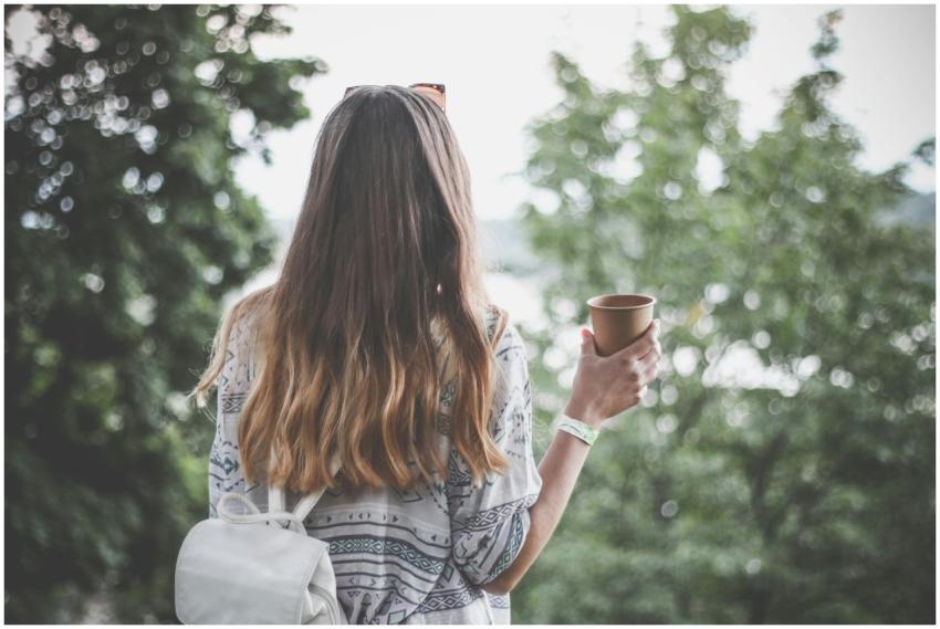 Back view of a young woman with long hair holding