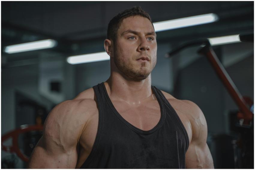 Muscular man with beard in black tank top focused