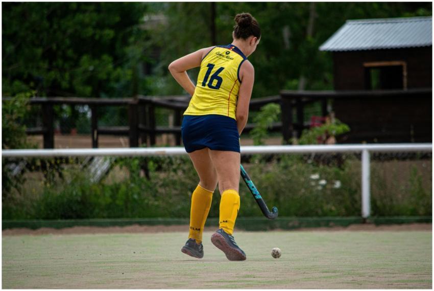 Female field hockey player wearing yellow jersey a