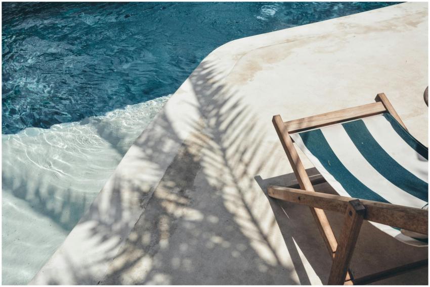 Serene poolside lounger with palm shadows, perfect