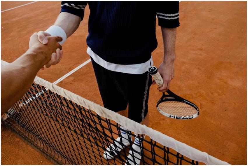A close-up of tennis players shaking hands over th