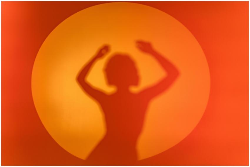 A silhouette of a woman's shadow dancing against a