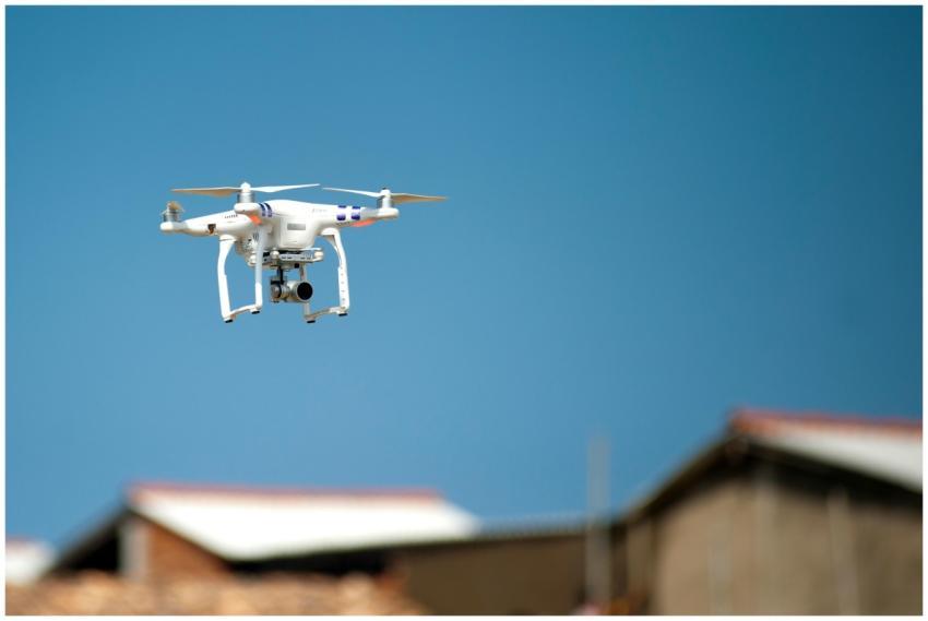 Aerial drone with camera hovering over rooftops be