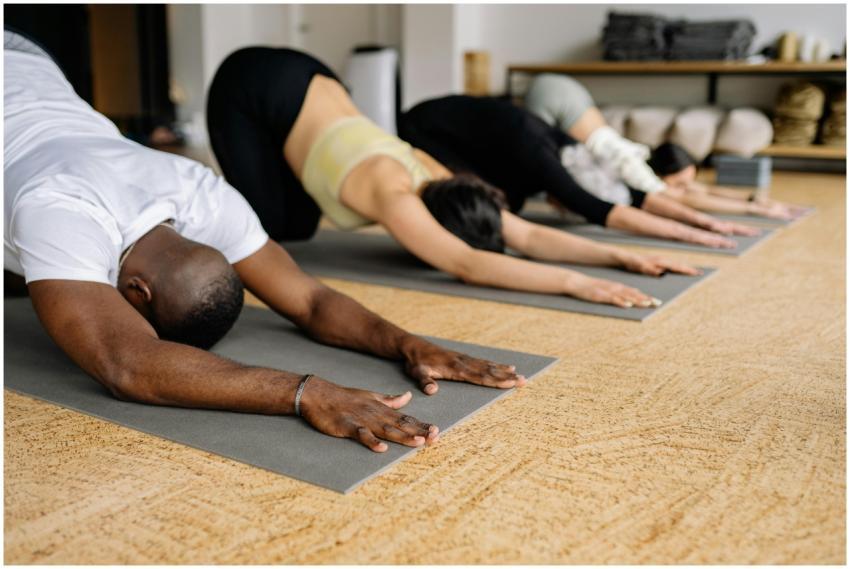 People practicing yoga indoors on mats, focusing o