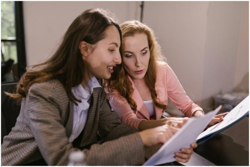 Two businesswomen discussing documents during an i