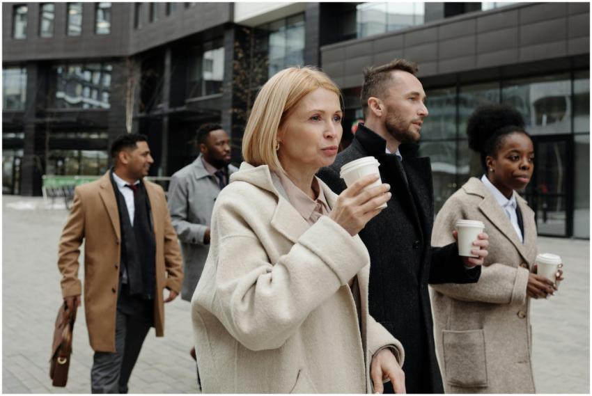 Business team walking outside with coffee, discuss