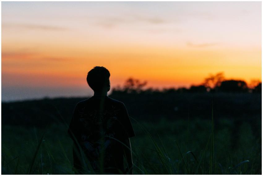 A person silhouetted against a vibrant Salvadoran