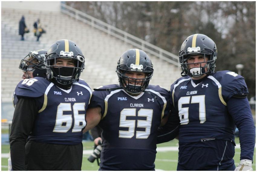 Three football players pose in uniforms at a colle