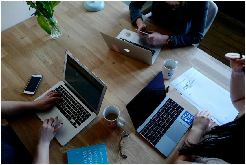 Overhead view of a modern workspace with laptops,