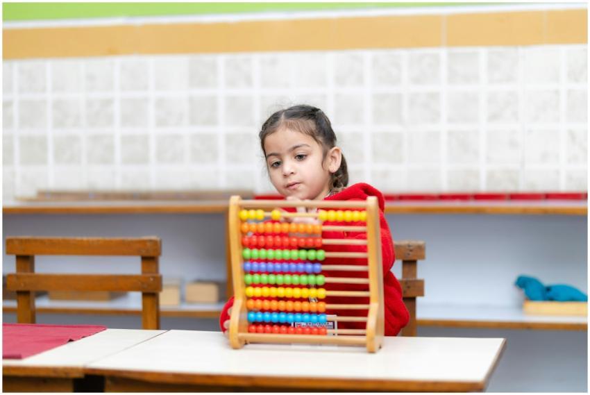Young child uses colorful abacus in a bright class