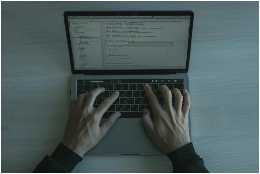 Close-up view of a programmer coding on a laptop,