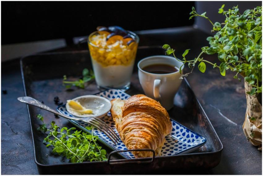 A delicious breakfast setup with a croissant, coff