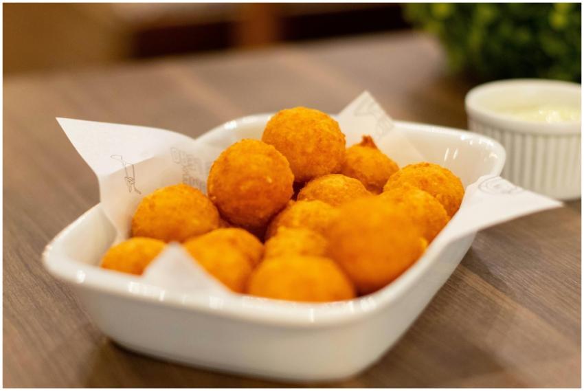 A close-up of crispy cheese balls served in a whit