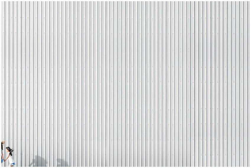 Silhouette of a woman running against a corrugated