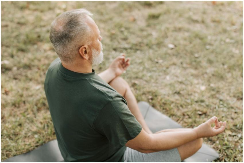 Senior man practicing yoga in a serene outdoor set