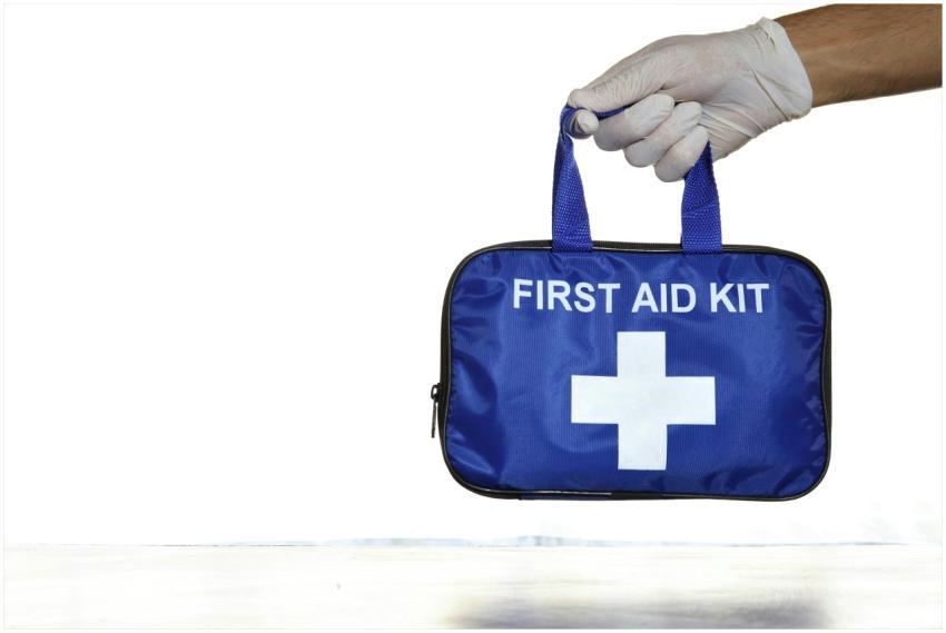 Close-up of a blue first aid kit held by a hand in