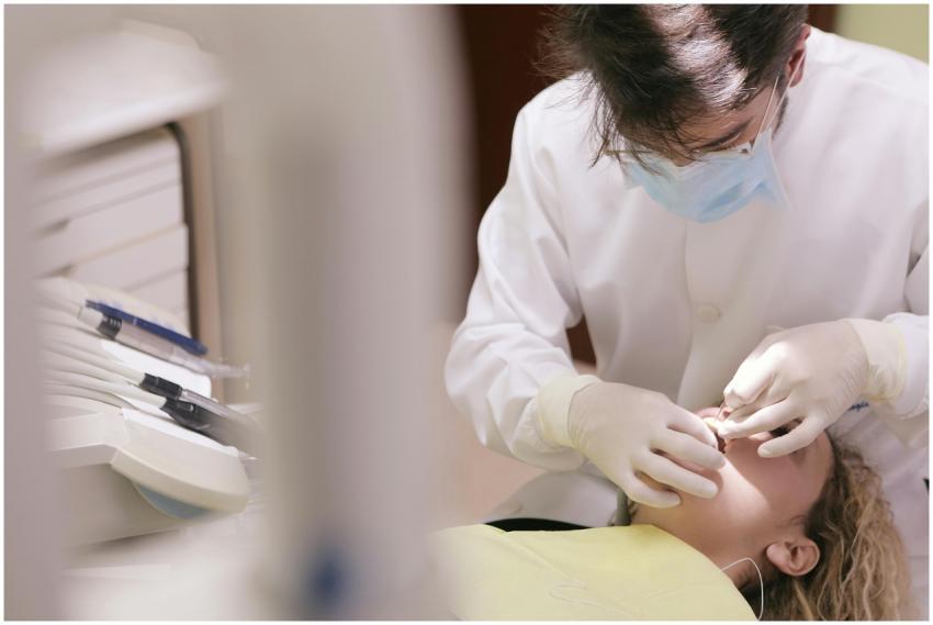 Dentist in mask and gloves providing dental care t