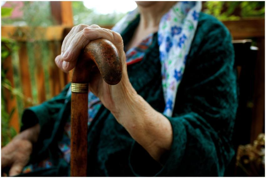 Senior adult holding a wooden cane, symbolizing st