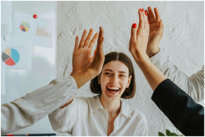 Diverse colleagues share a joyful high five, showc