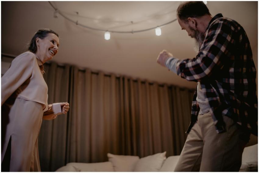 A lively senior couple dancing indoors with smiles