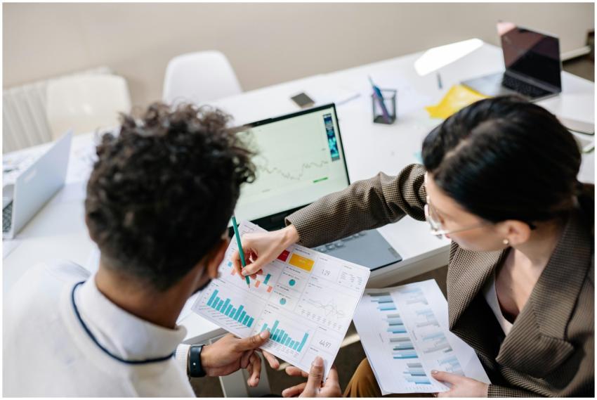 Two colleagues in a meeting room discussing financ