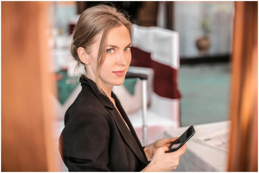 Young businesswoman using smartphone indoors with