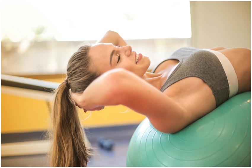 A woman in a gym smiling while exercising on a sta