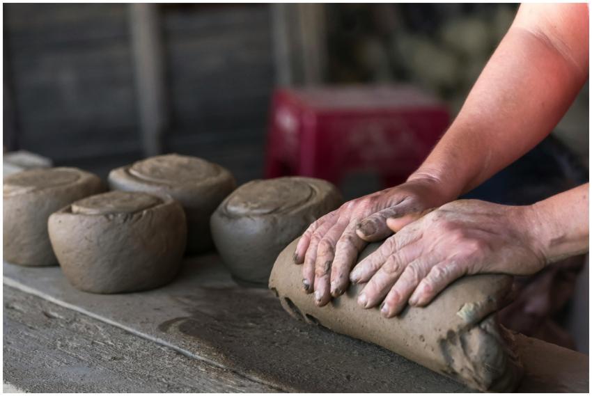 Hands of a craftsman kneading clay in preparation