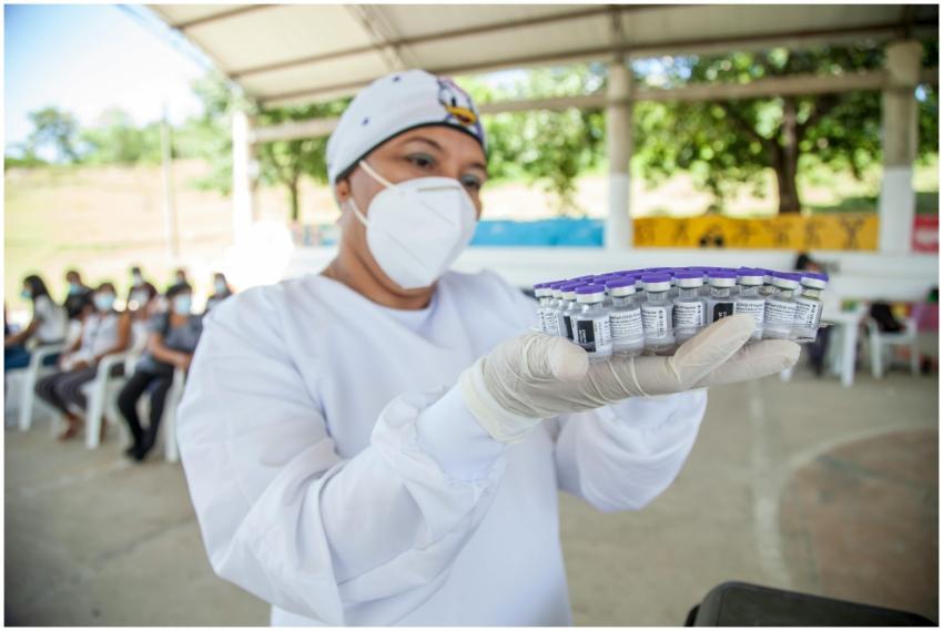 Health worker in Colombia holding vaccine vials at