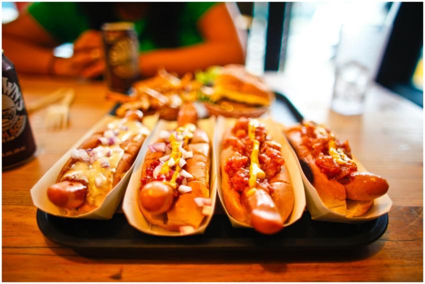 Close-up of various hotdogs with toppings on a woo