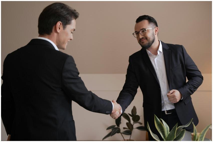 Two businessmen shaking hands in an office, symbol