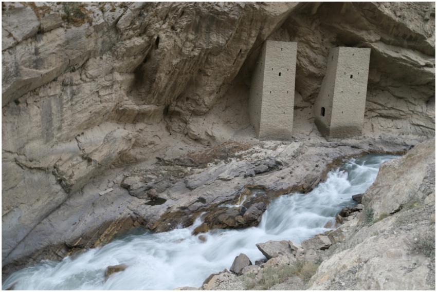 Ancient stone towers nestled in a rocky canyon wit