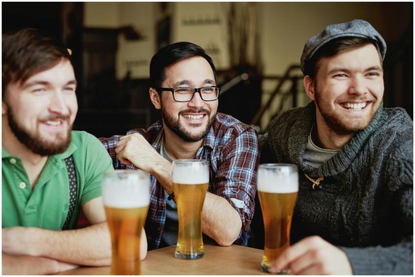 Group of young friends happily enjoying beers toge