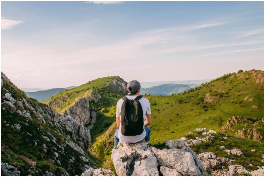 Man sitting on rocks with a scenic mountain view i