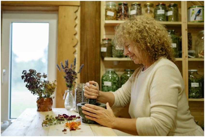 Woman grinding herbs in a mortar for natural remed