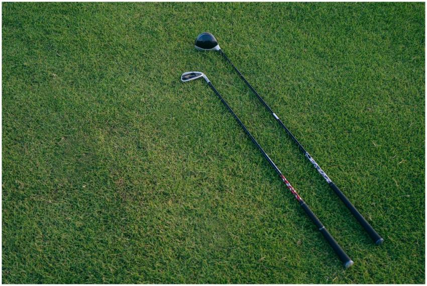 Two golf clubs lying on a lush green golf course,