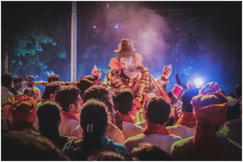 A vibrant night scene of people celebrating Ganesh