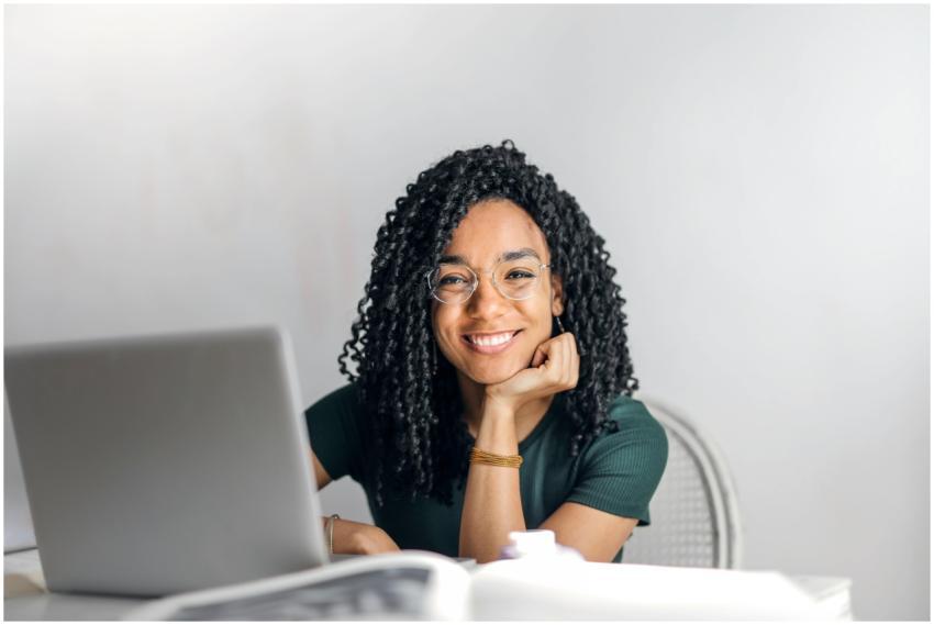 Joyful businesswoman with curly hair smiling at ca