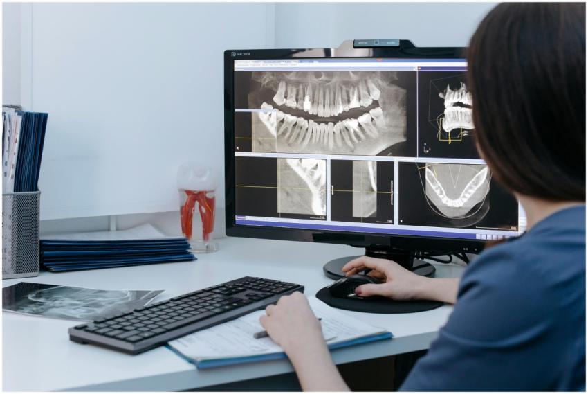 Dentist examining dental X-rays on a computer scre